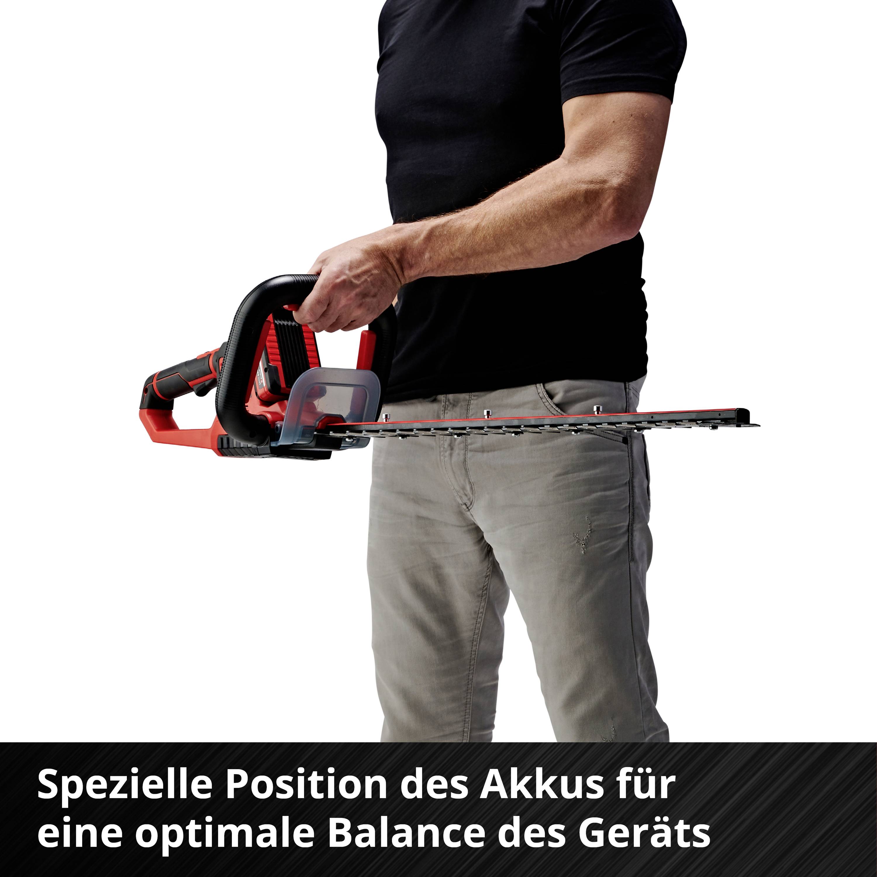Person hält eine Motorsäge mit rotem Griff in der rechten Hand. Unten steht: 'Spezielle Position des Akkus für eine optimale Balance des Geräts'.
