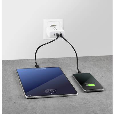 Ein Tablet und ein Smartphone werden gleichzeitig an einer Steckdose geladen. Das Smartphone zeigt einen grünen Ladebalken.