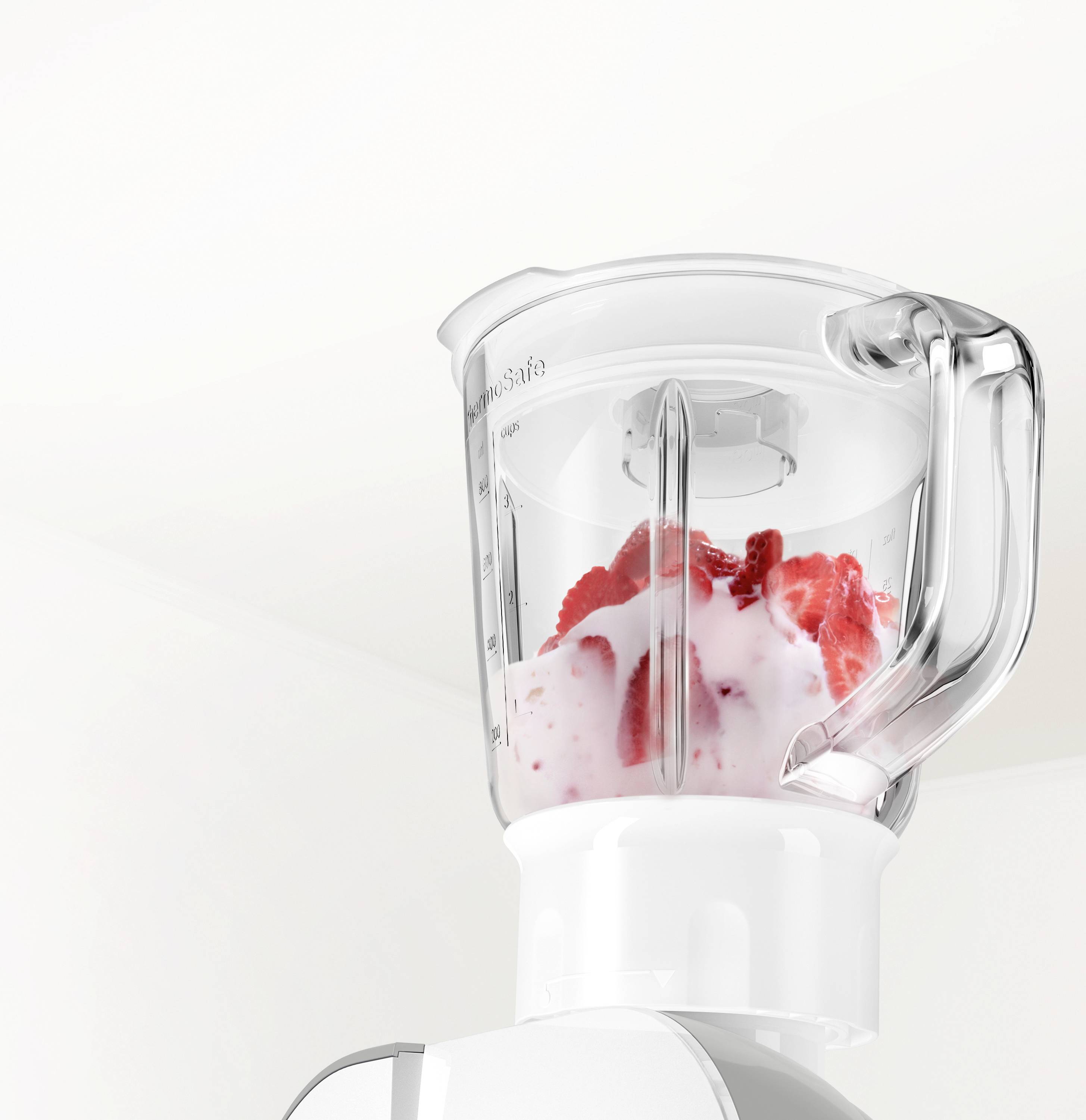 Ein Mixer-Krug mit Erdbeeren und Joghurt, bereit zum Mixen eines Smoothies. Der Mixer steht in einer hellen Küche.