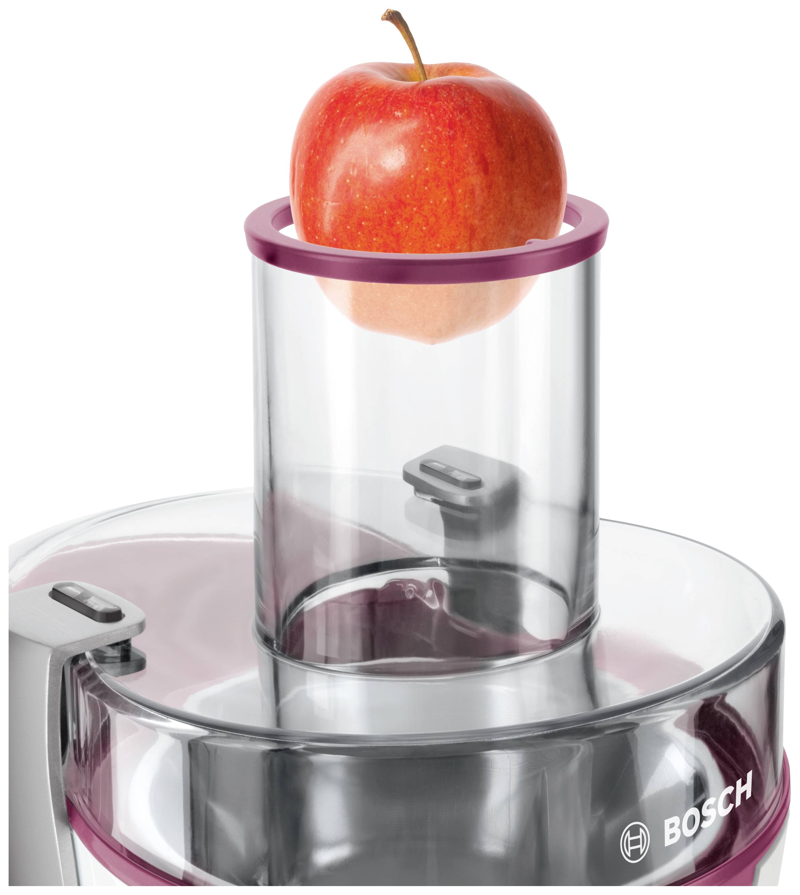 Ein roter Apfel liegt im Einfüllschacht eines Bosch Entsafters, bereit zur Verarbeitung.