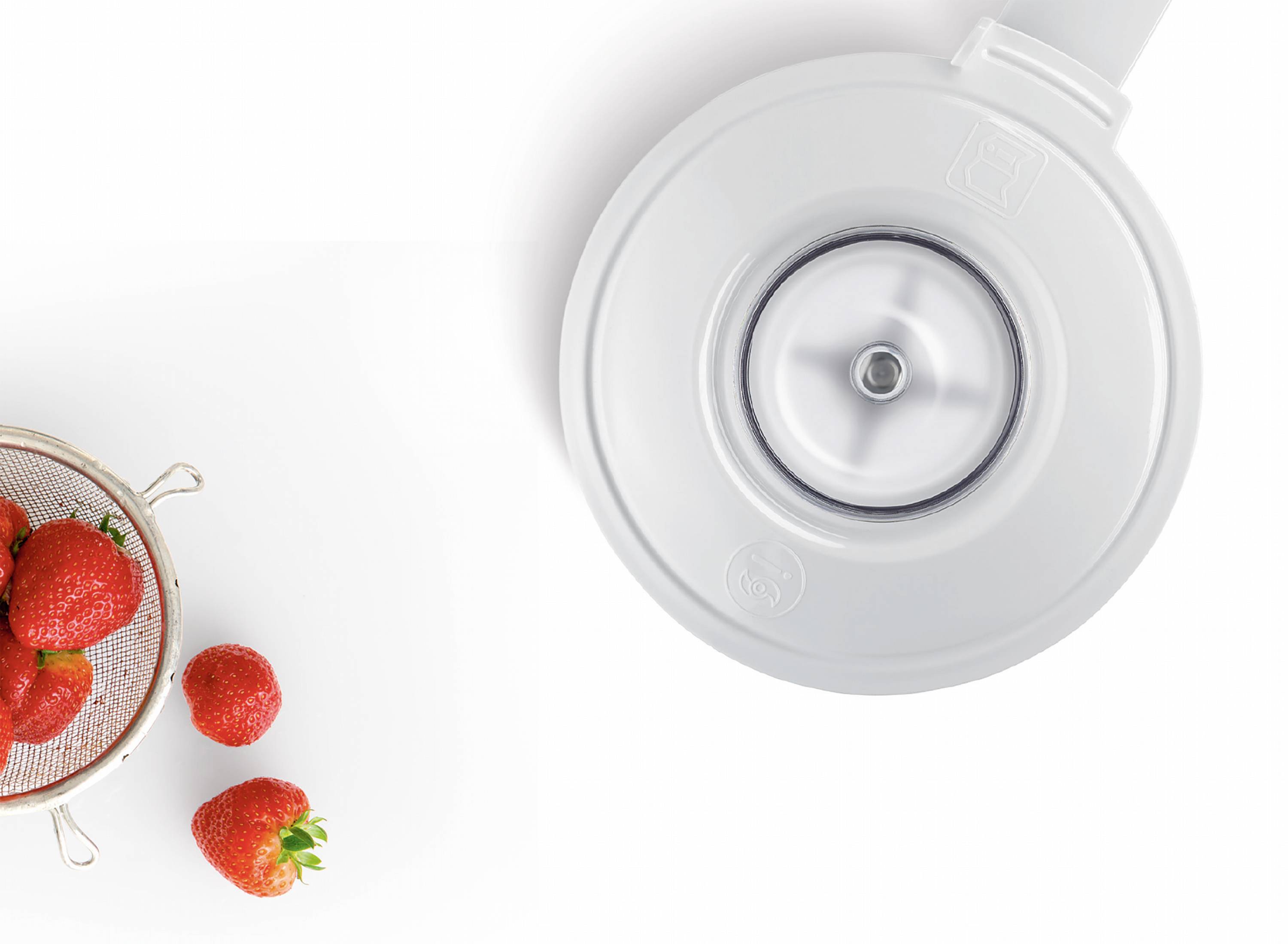 Ein Sieb mit frischen Erdbeeren neben einem weißen Küchengerät von oben betrachtet.