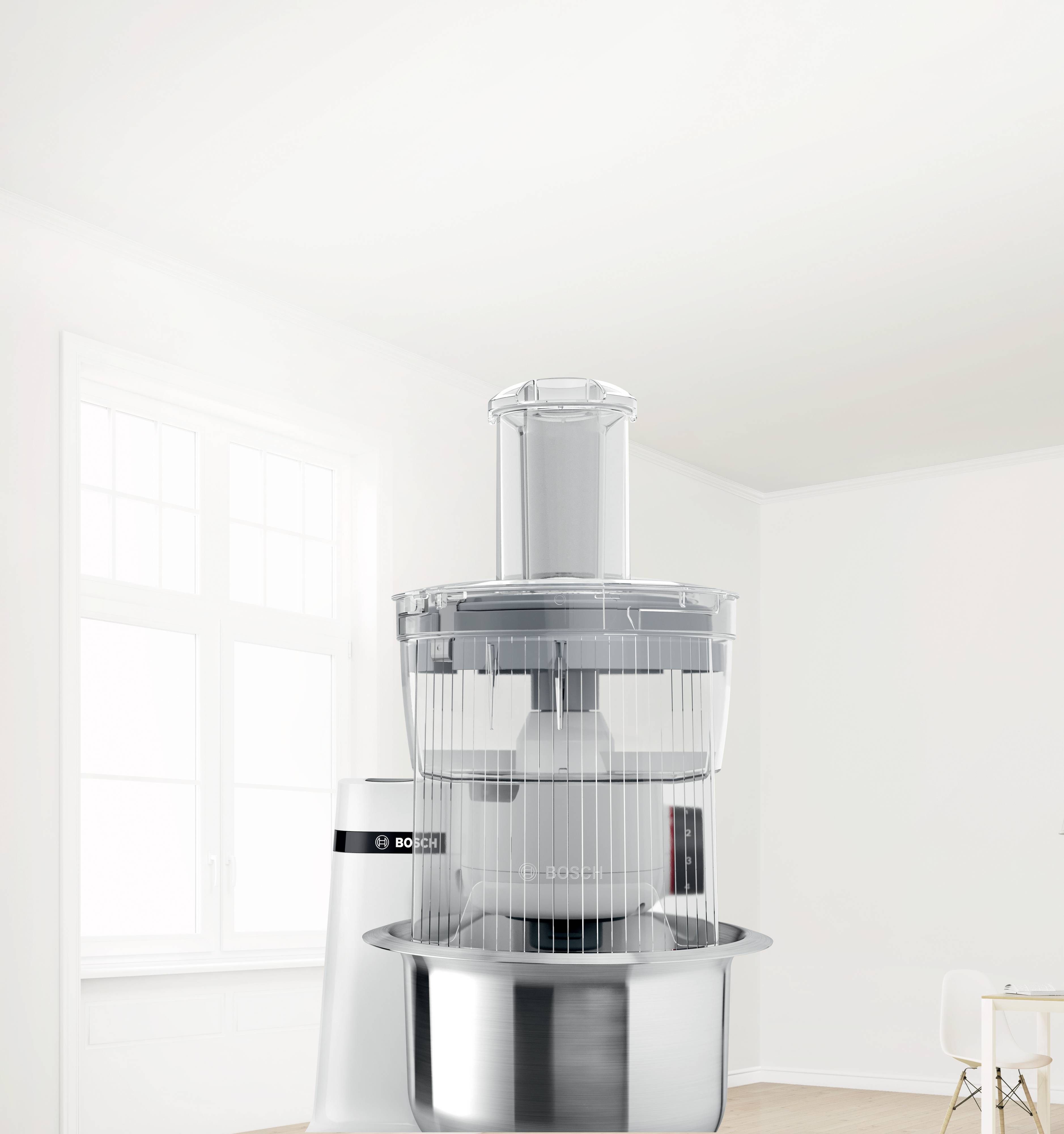 Eine silberne Küchenmaschine steht in einem hellen, modernen Raum mit großen Fenstern und weißen Wänden.