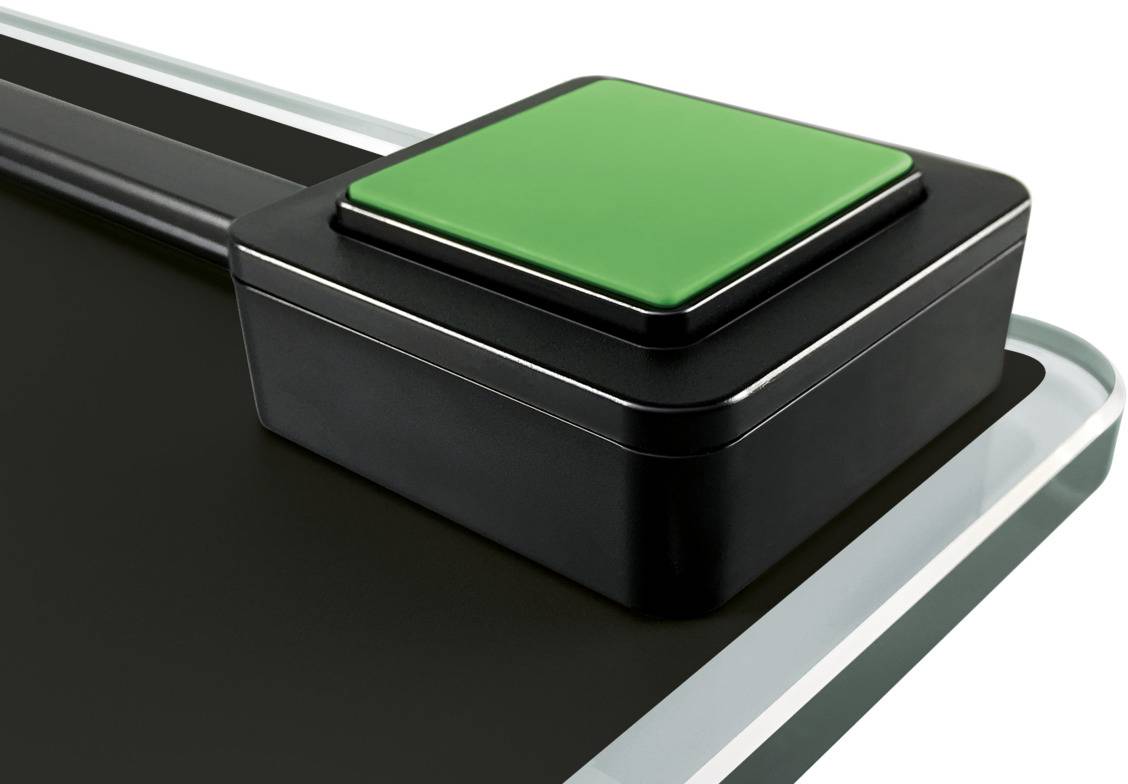 Ein großer, grüner Schalter auf einer schwarzen Oberfläche.