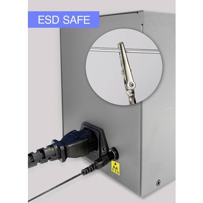 Ein silbernes Gerät mit Kabelanschlüssen. Ein Kreisfenster hebt eine Krokodilklemme hervor. Oben links steht 'ESD SAFE'.