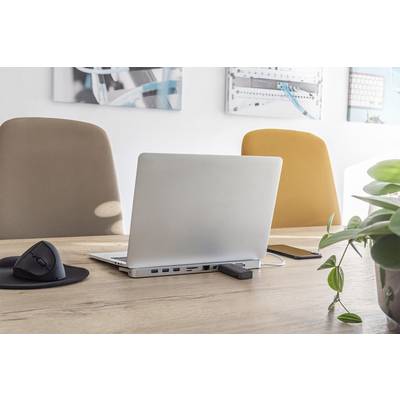 Ein Laptop steht auf einem Holzschreibtisch zwischen zwei leeren Stühlen. Daneben liegen eine Computermaus und ein Smartphone.