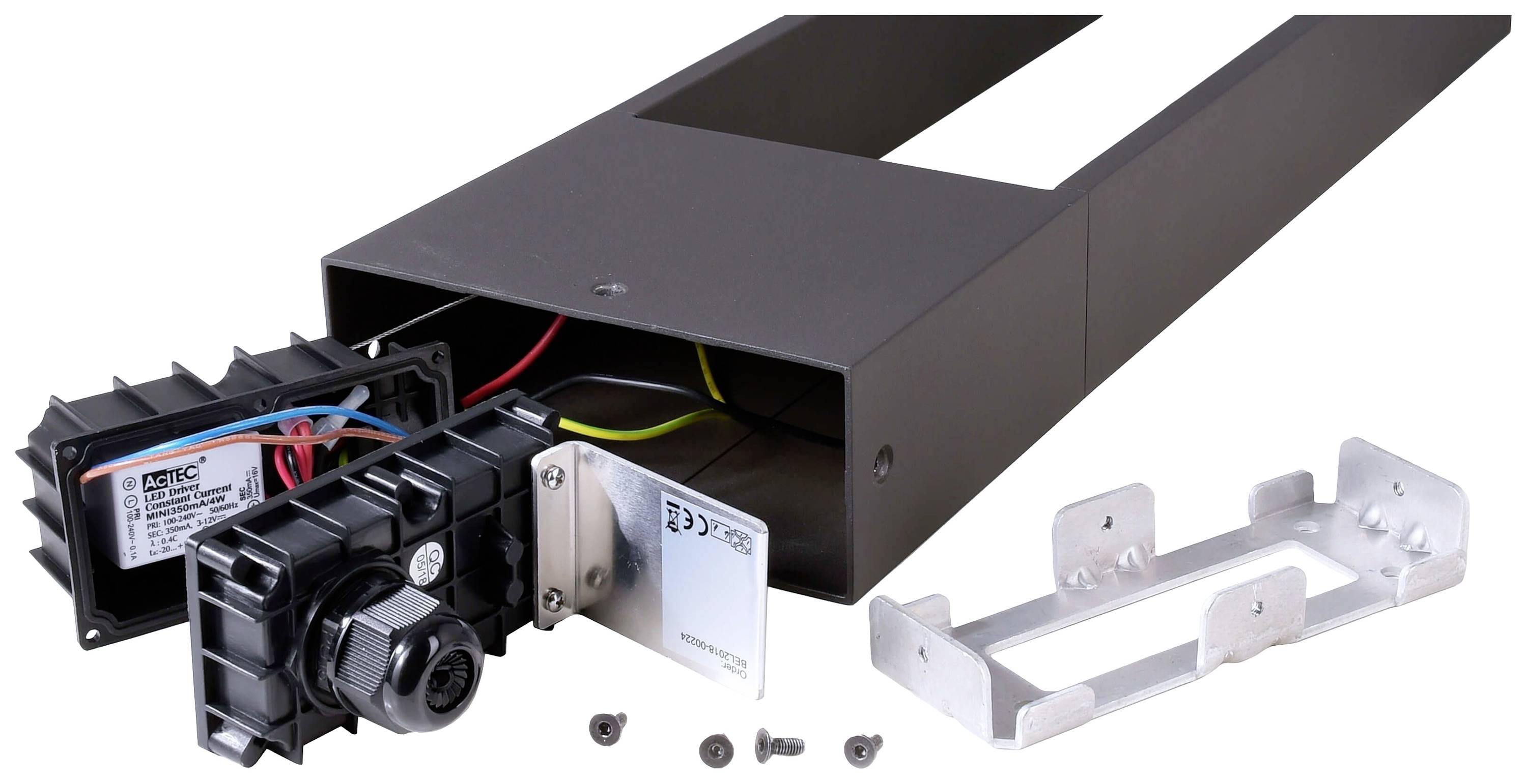 Metallisches Bauteil mit geöffnetem Gehäuse, das verschiedene elektrische Komponenten wie Kabel und ein Steuergerät zeigt. Schrauben liegen daneben.