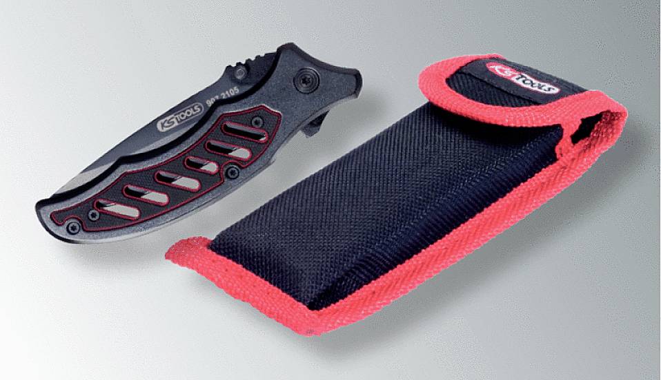 Ein schwarzes Klappmesser mit roten Akzenten neben einem schwarzen Etui mit roten Nähten, liegend auf grauem Hintergrund.