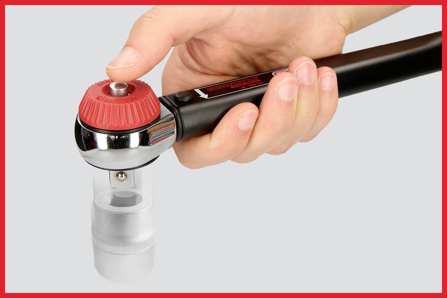 Eine Hand hält ein medizinisches Instrument mit rotem Knopf und Glaslinse, verwendet zur Hautuntersuchung.