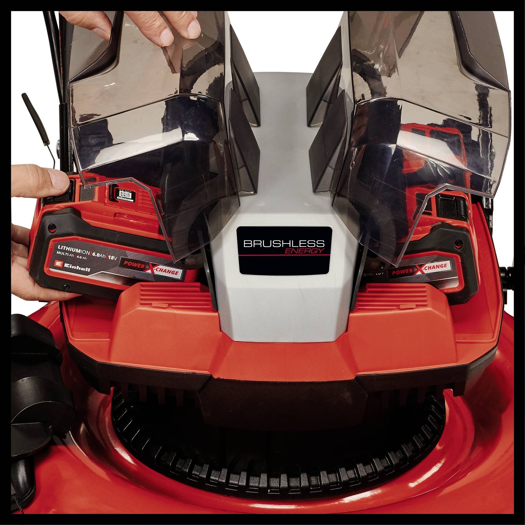 'Hände legen Batterien in einem Rasenmäher ein. Aufschrift 'Brushless Motor'. Akku von Marke mit 'Lithium-Ionen 18V'.'