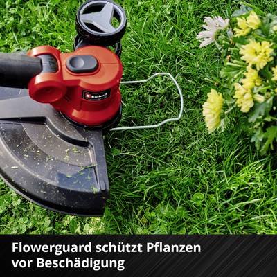 Ein Rasentrimmer mit 'Flowerguard' Schutz arbeitet in einem Garten, umgeben von grünem Gras und gelben Blumen.