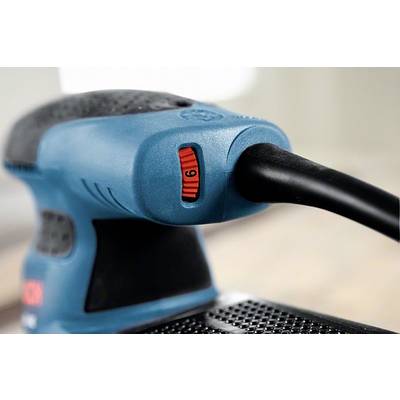 Ein blauer Elektroschleifer mit schwarzem Griff und rotem Geschwindigkeitsregler in der Einstellung 6, liegt auf einem Holztisch.