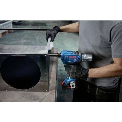 Person bearbeitet Metall mit einer blauen Bohrmaschine. Der Bohrer wird an einer großen Metallbox verwendet. Arbeiter trägt schwarze Handschuhe.