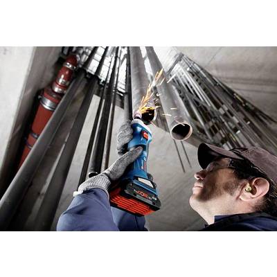 Eine Person schneidet mit einem elektrischen Werkzeug ein Metallrohr. Funken sprühen vom Rohr. Schutzkleidung wird getragen.