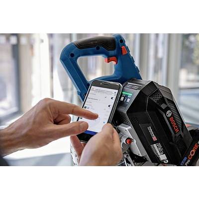 Eine Hand bedient ein Smartphone, das mit einem Bosch-Elektrowerkzeug verbunden ist. Auf dem Bildschirm sind Einstellungen sichtbar.