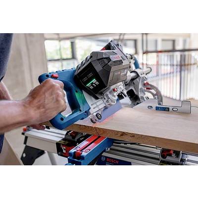 Eine Person benutzt eine Bosch-Handkreissäge, um ein Holzbrett präzise zuzuschneiden. Die Säge zeigt digitale Informationen an.