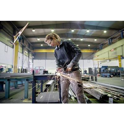 Eine Person trägt Schutzbrille und Handschuhe und schleift Metall mit einem Winkelschleifer in einer industriellen Werkstatt. Funken fliegen.