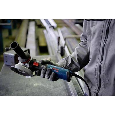 Eine Person hält einen blauen Winkelschleifer in der Hand, bereit zum Einsatz in einer Werkstatt mit Metallleisten im Hintergrund.