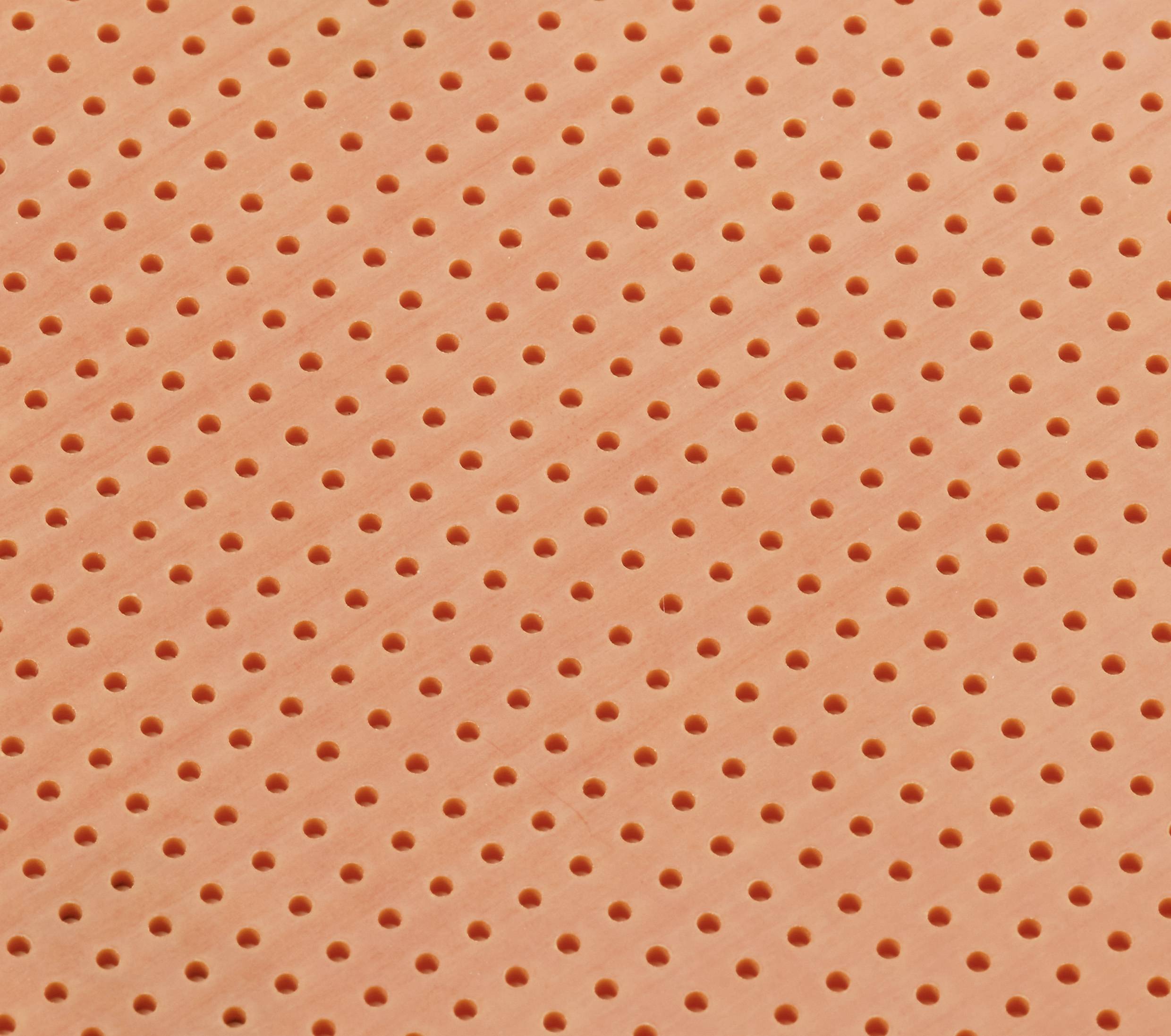 Ein hautfarbenes Pflaster mit kleinen, regelmäßig verteilten Löchern für Flexibilität und Atmungsaktivität.