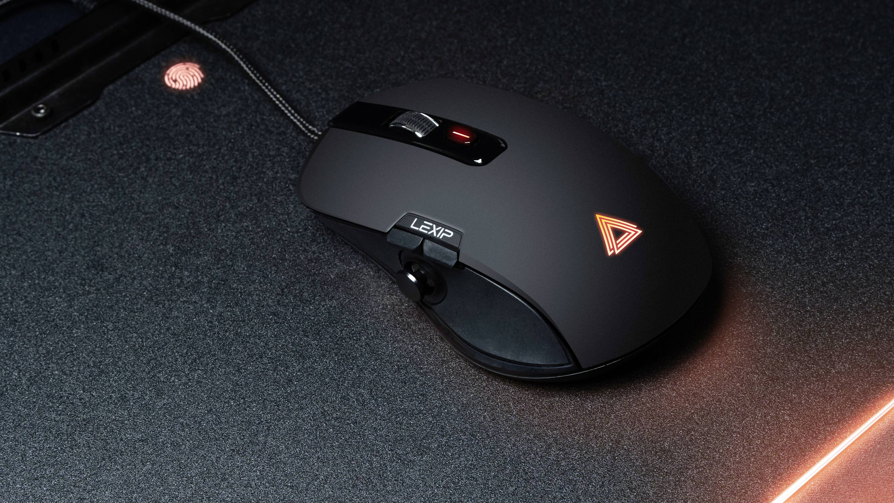 Computermouse mit Kabel auf einem dunklen Untergrund. Die Maus hat ein leuchtendes Logo und ein Scrollrad.
