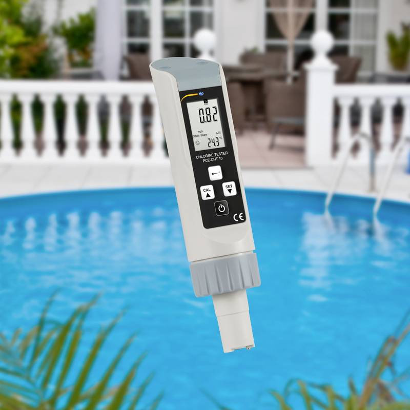 Ein digitales Pooltester-Gerät über einem blauen Swimmingpool. Zeigt Messungen für Chlor- und pH-Wert an. Hintergrund mit Poolumgebung.