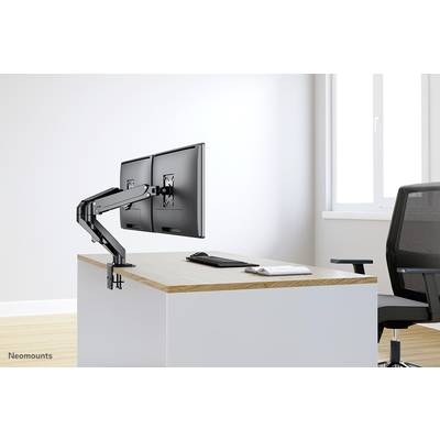 Zwei Monitore an einem flexiblen Armhalter auf einem Schreibtisch mit Tastatur und Maus. Ein leerer Stuhl steht daneben.