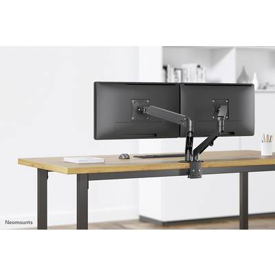 Ein moderner Schreibtisch mit zwei nebeneinander montierten Monitoren auf einem verstellbaren Arm, eine Tastatur darunter und eine Tasse rechts.
