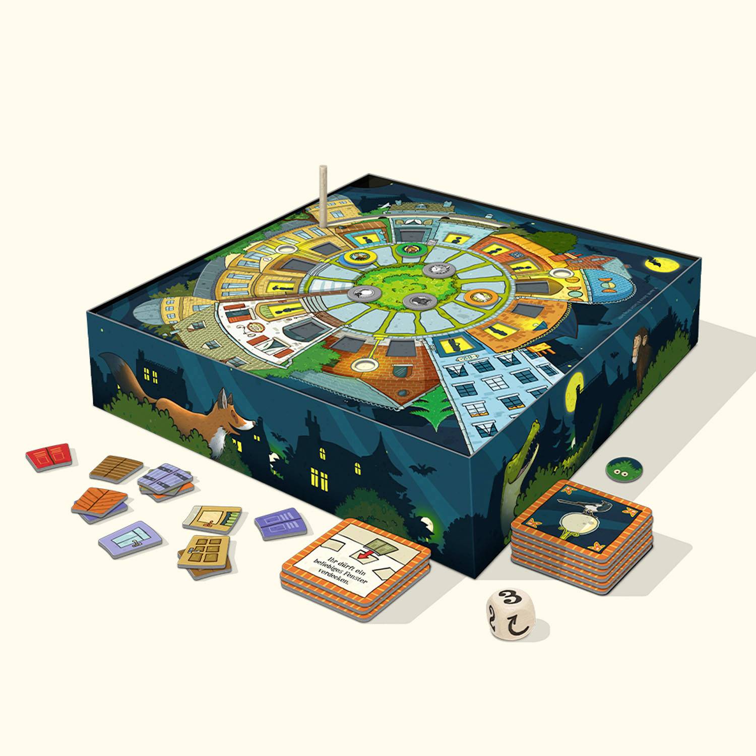 Ein Brettspiel mit rundem Spielbrett zeigt eine Stadt mit Häusern und Wegen. Kartenstapel und Spielchips liegen daneben, ein Würfel zeigt die Zahl 3.