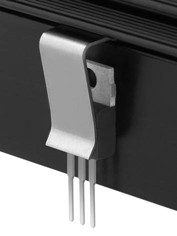 Ein Metallclip an einem schwarzen Gehäuse, der drei Stifte hält. Technische Komponente mit Fokus auf Verbindung und Stabilität.