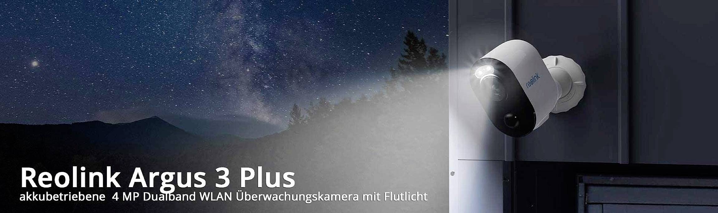 Überwachungskamera Reolink Argus 3 Plus mit Flutlicht, montiert an einer Wand, beleuchtet eine nächtliche Landschaft mit Sternenhimmel.