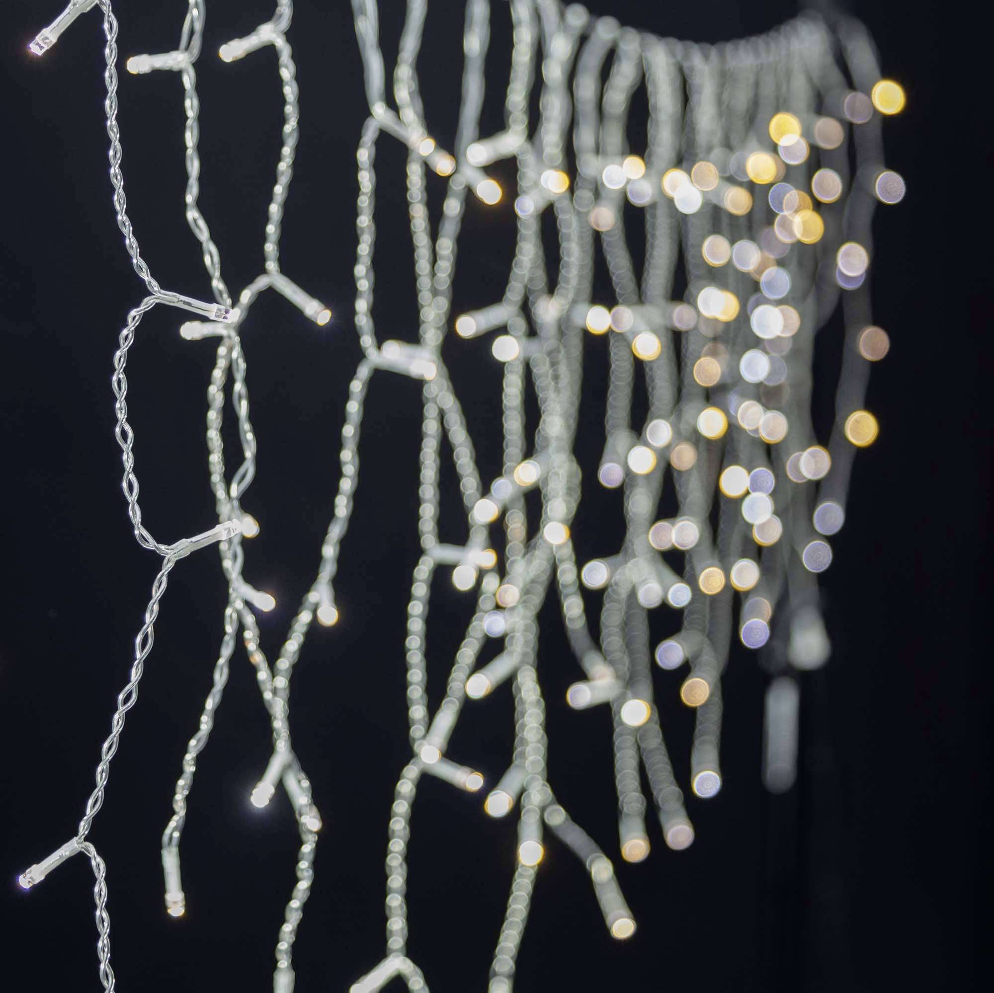 Lichterkette mit unscharfen, leuchtenden Punkten auf schwarzem Hintergrund. Die Lichter leuchten in warmen Gelbtönen.