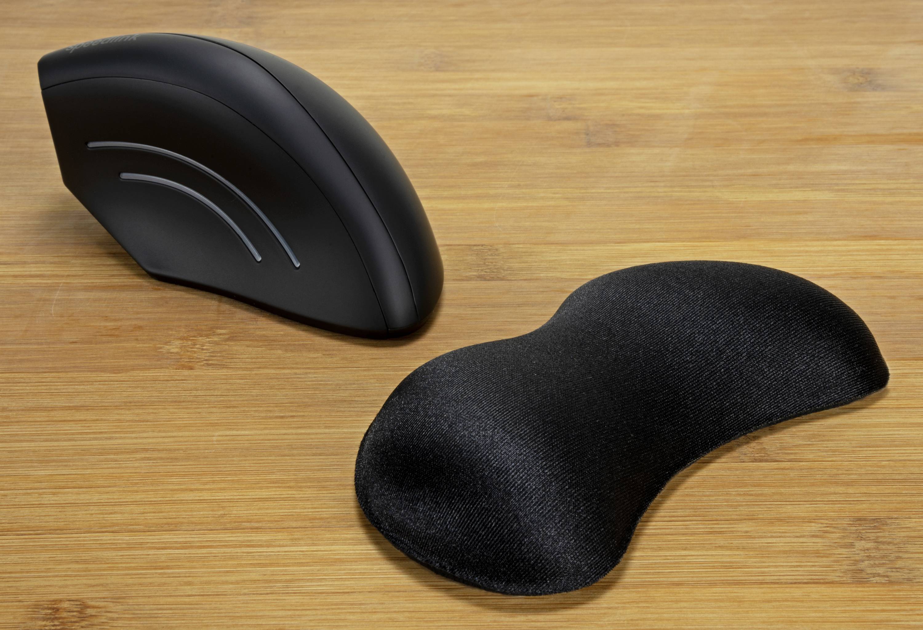 Ergonomische Computermaus und Handgelenkauflage auf einem Holzschreibtisch. Ideal für komfortables Arbeiten und Handgelenkunterstützung.