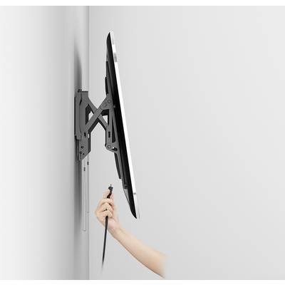 'Abgebildet ist ein an der Wand montierter Monitor, der von einer Hand mit einem Kabel verbunden wird.'