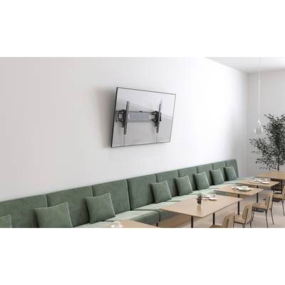 Ein Besprechungsraum mit einer langen grünen Couch, Holztischen und einem großen, an der Wand montierten Flachbildschirm.