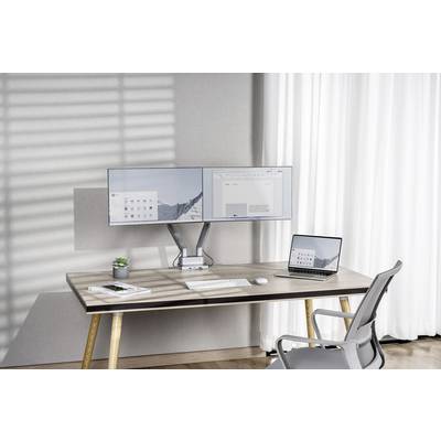 Ein Schreibtisch mit zwei Monitoren, einem Laptop, Tastatur und Maus. Im Hintergrund große Fenster mit weißen Vorhängen.