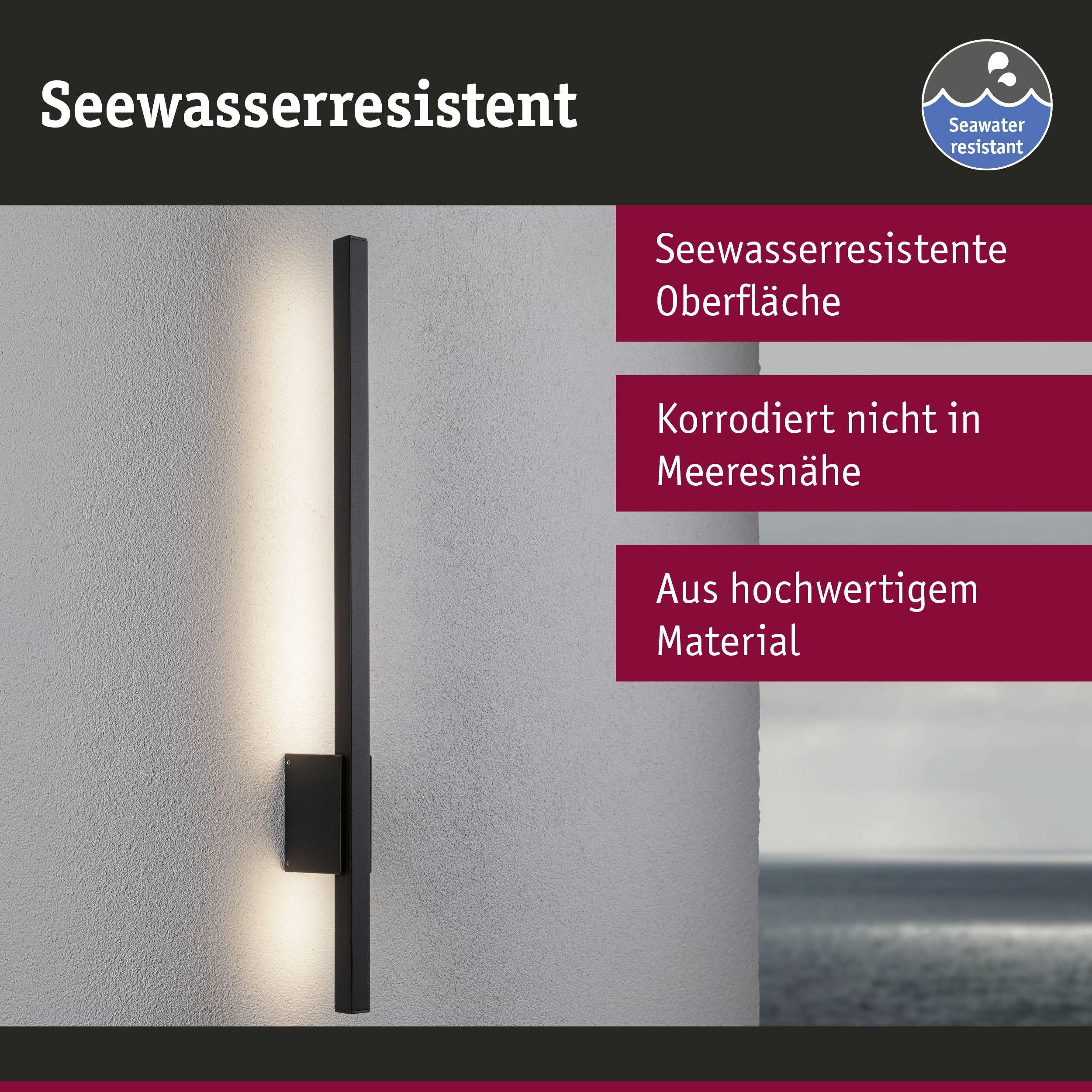 Wandleuchte mit 'Seewasserresistent' Aufschrift, zeigt ihre Anpassung an Korrosion. Hintergrund mit Küstenlandschaft.