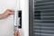 Eine Person installiert oder repariert eine Jalousie an einem Fenster, indem sie das Gurtband in eine Wandhalterung einführt.
