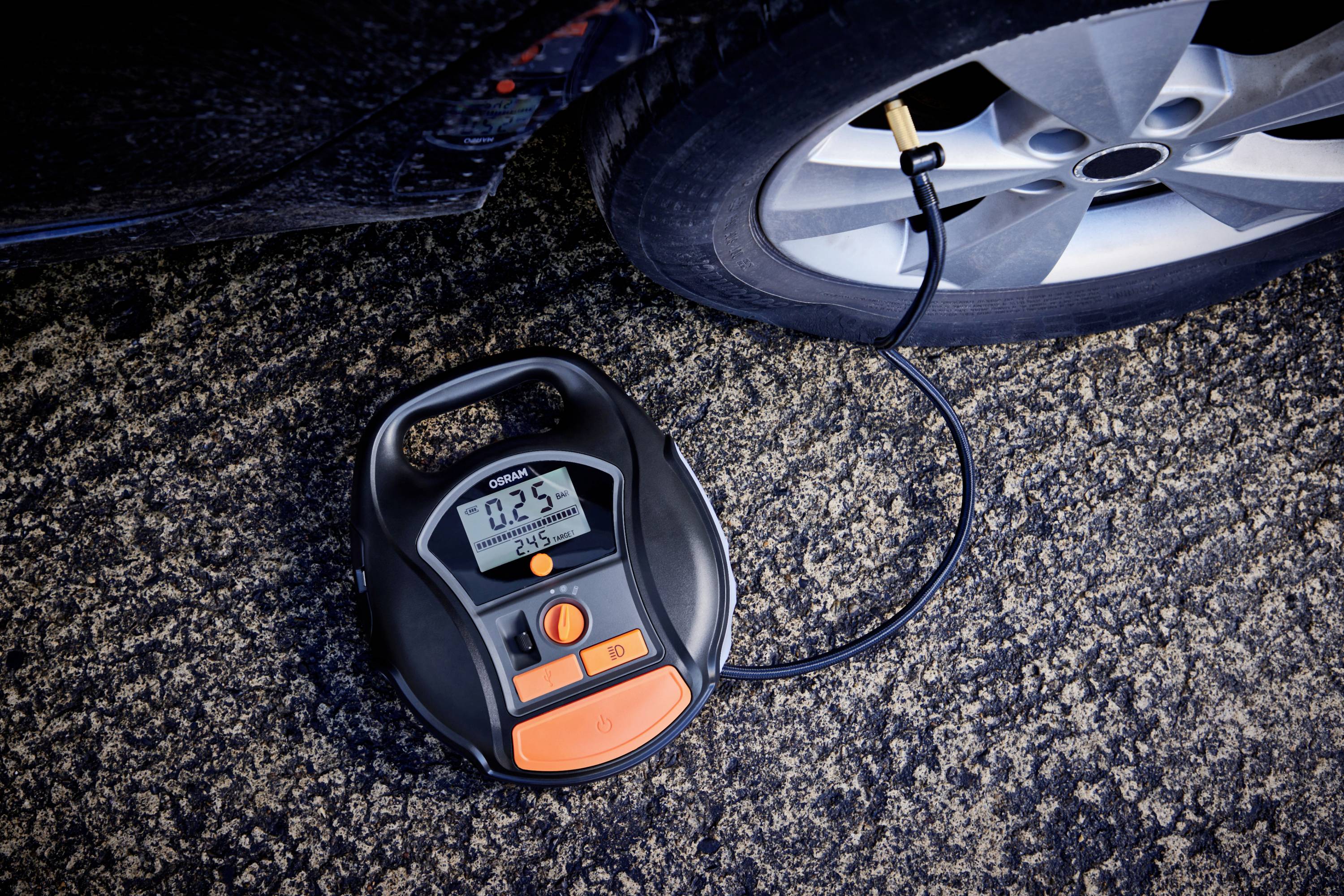 Ein digitaler Reifenfüller pumpt einen Autoreifen auf. Das Display zeigt '0.25', entsprechend dem aktuellen Druckstand des Reifens.