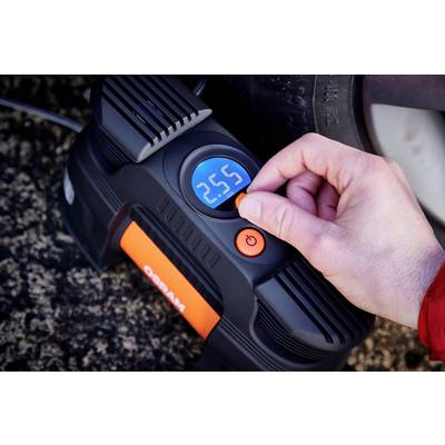 Eine Hand stellt einen digitalen Kompressor auf 2,55 Bar ein, um einen Autoreifen zu befüllen.
