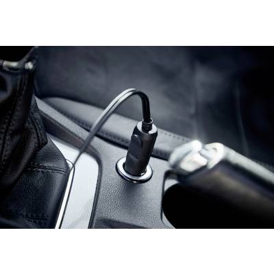 Ein Ladekabel steckt in einer Autosteckdose. Das Foto zeigt eine Nahaufnahme im Fahrzeuginnenraum mit Fokus auf die Steckverbindung.