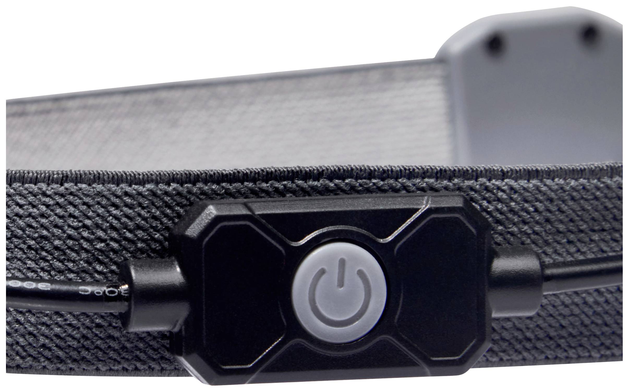 Ein schwarzer Schalter mit einem Power-Symbol in der Mitte, montiert an einem Kabel. Der Hintergrund ist unscharf, zeigt aber Struktur.