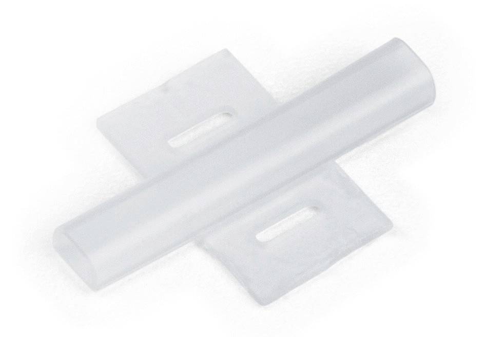 Ein transparenter Plastikverbinder in Kreuzform, bestehend aus einem horizontalen und einem vertikalen Teil, liegt auf einer hellen Oberfläche.