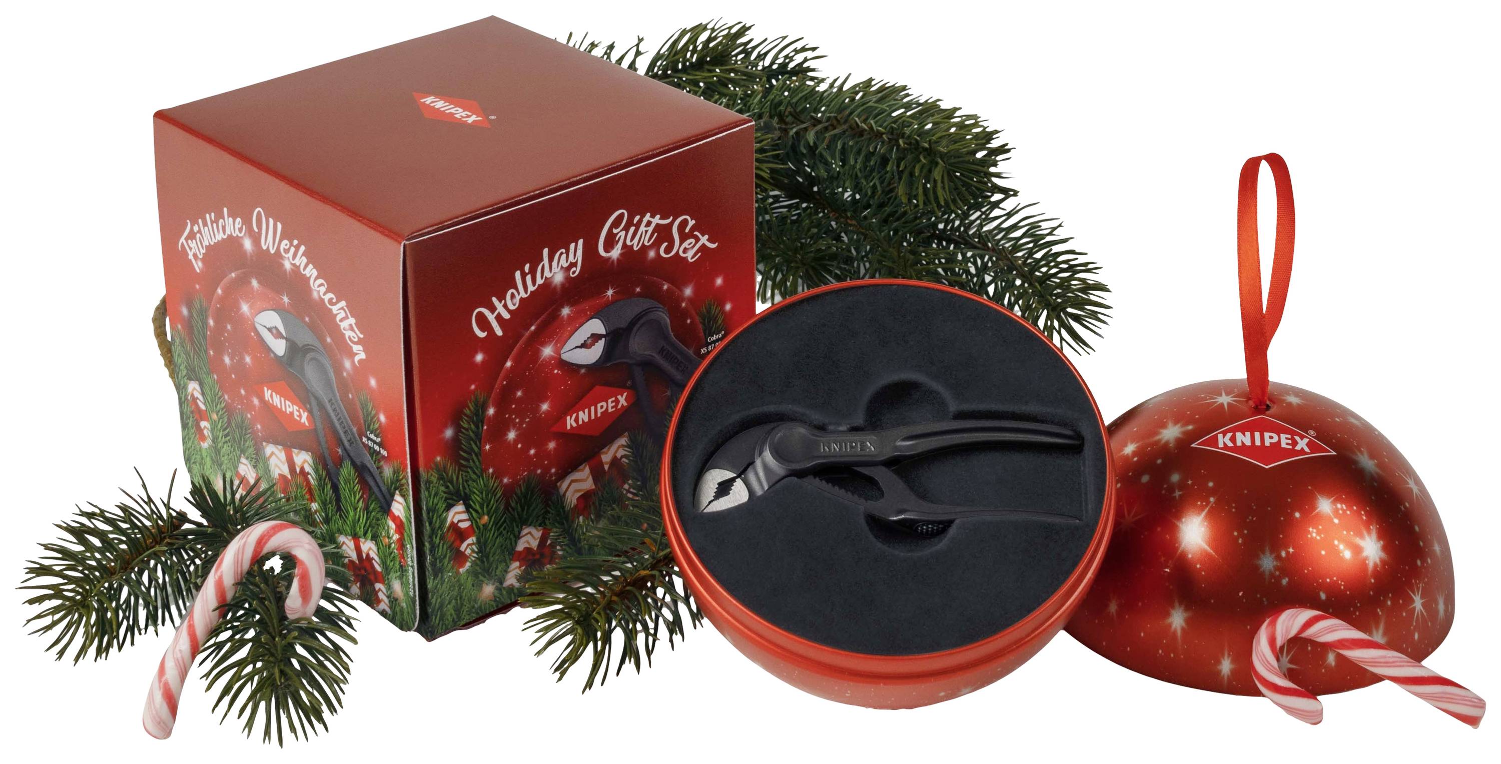 'Weihnachtsgeschenkset' von Knipex mit einer Zange, präsentiert in einer roten Kugelverpackung neben einem verzierten Karton und Tannenzweigen.
