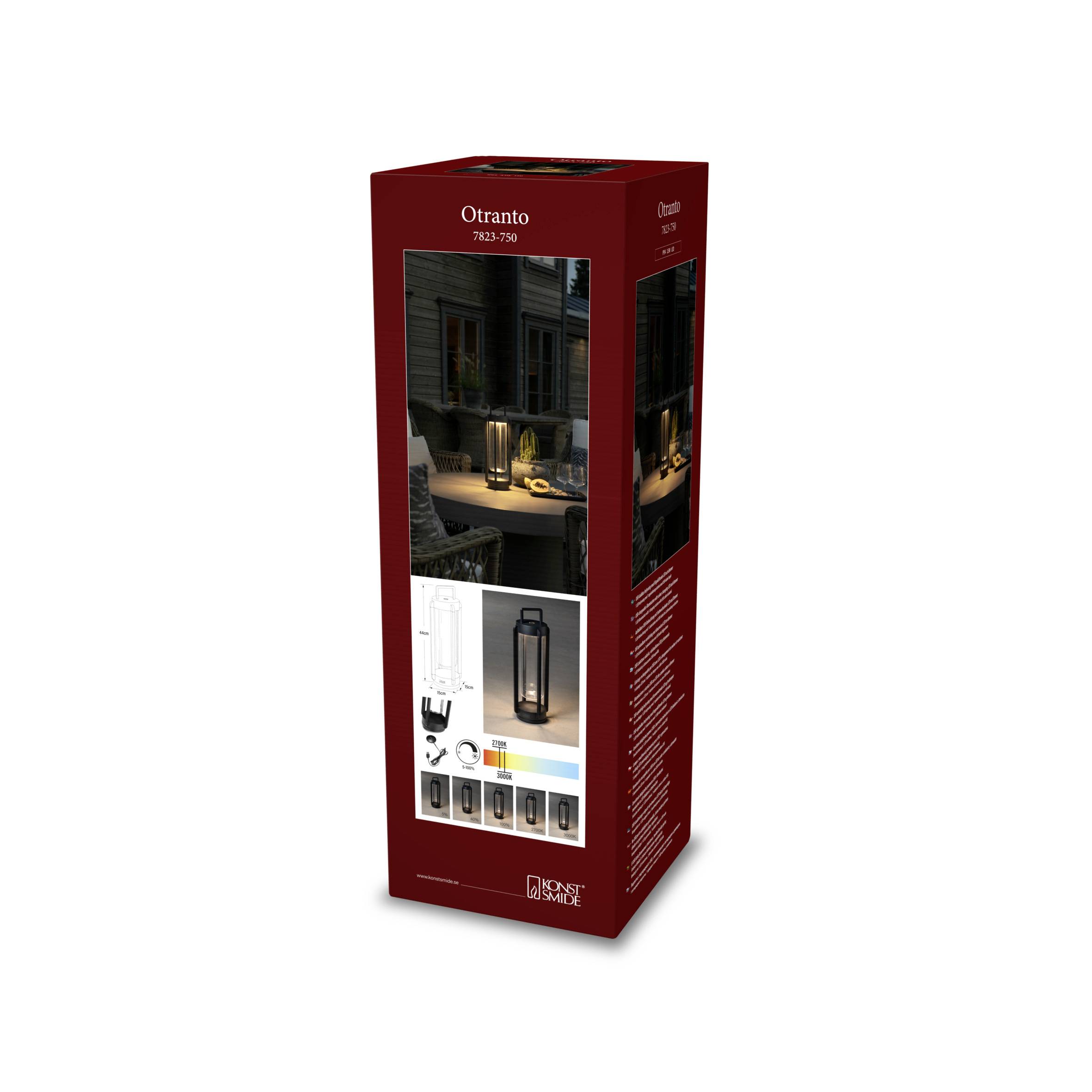Rote Verpackung einer Otranto Laterne mit Bild der leuchtenden Laterne auf einem Tisch im Freien. Enthält Produktmerkmale und Zubehör.