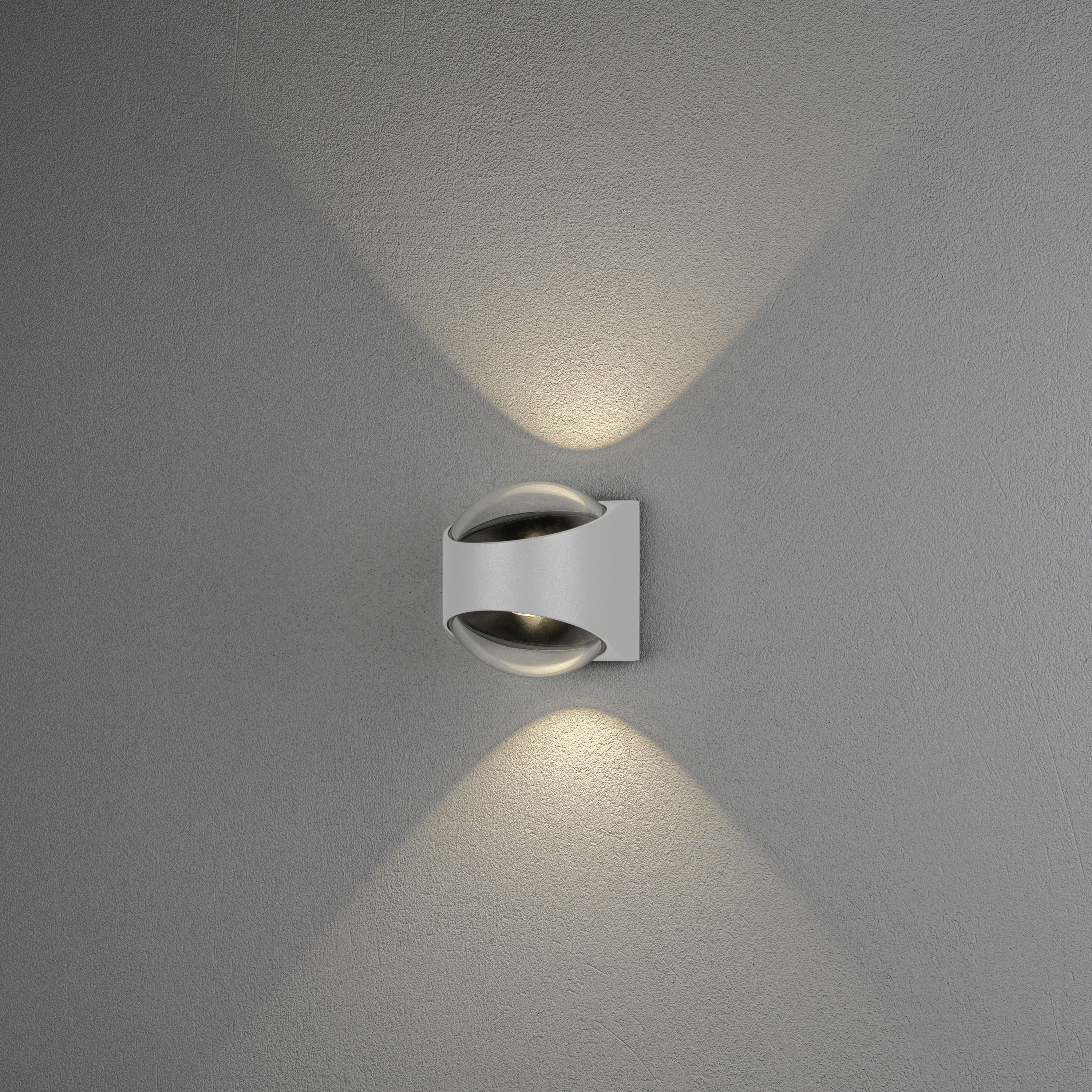 Wandleuchte mit modernem Design strahlt warmes Licht nach oben und unten, erzeugt ein stilvolles Ambiente auf grauer Wand.