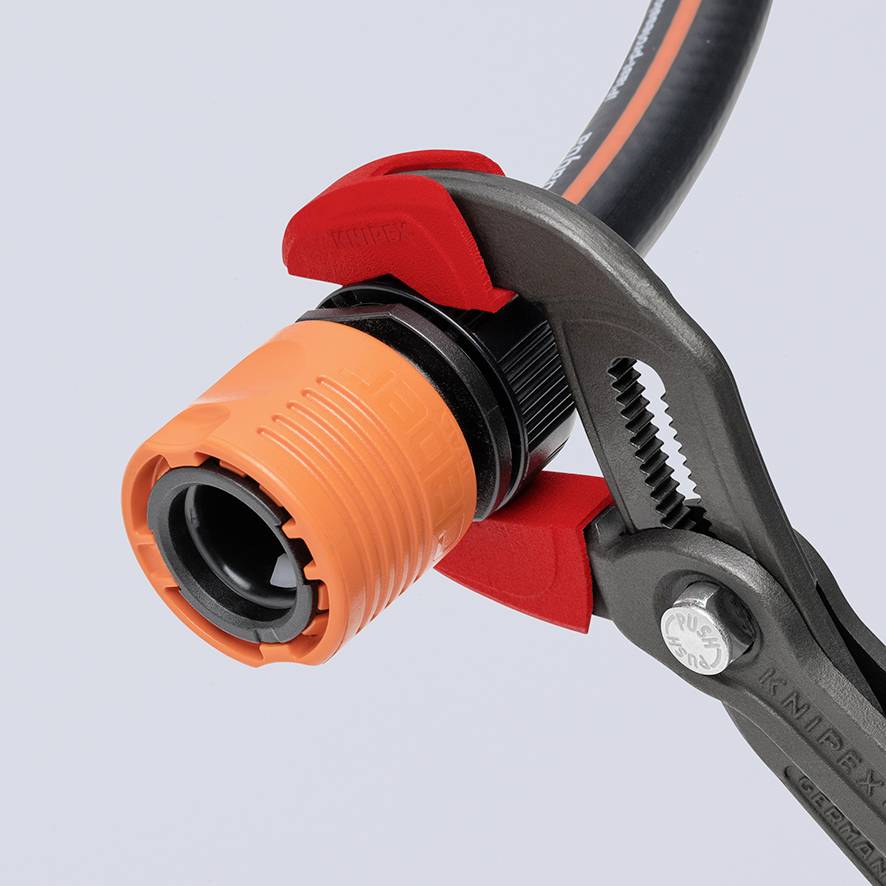Zange hält einen orangefarbenen Gartenschlauchanschluss. Fokussiert auf Reparatur oder Verbindung von Wasserschläuchen.