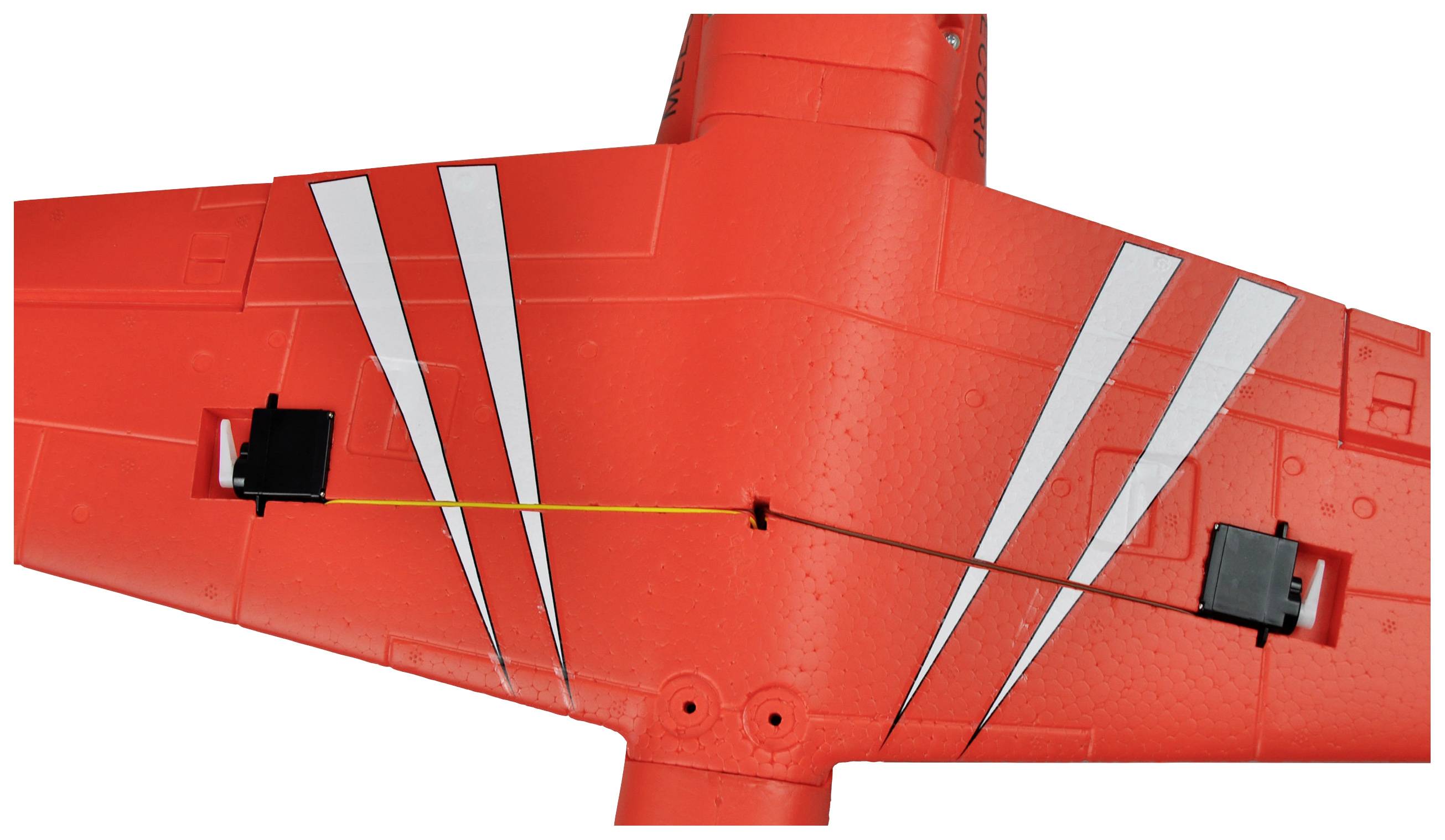 Ein roter Modellflugzeugflügel mit weißen Streifen. Zwei schwarze Servo-Mechanismen sind an den Flügelenden sichtbar.