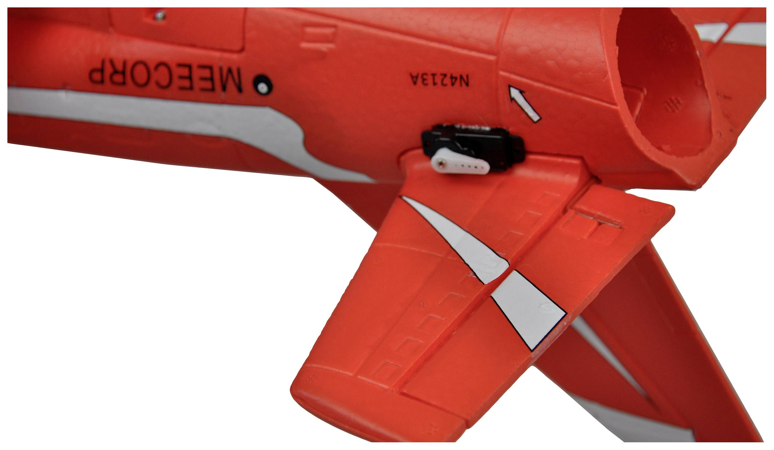 Rotes Modellflugzeug mit weißem Streifen und der Aufschrift 'MEECORP' auf der Seite des Rumpfes. Flügel zeigt detailreiche Strukturen.