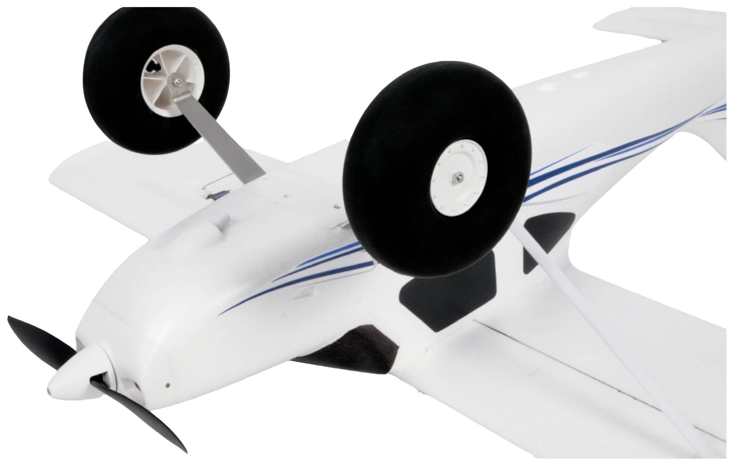 Ein weißes Modellflugzeug liegt auf dem Rücken. Zwei große schwarze Räder sind sichtbar. Das Flugzeug hat blaue Streifen.