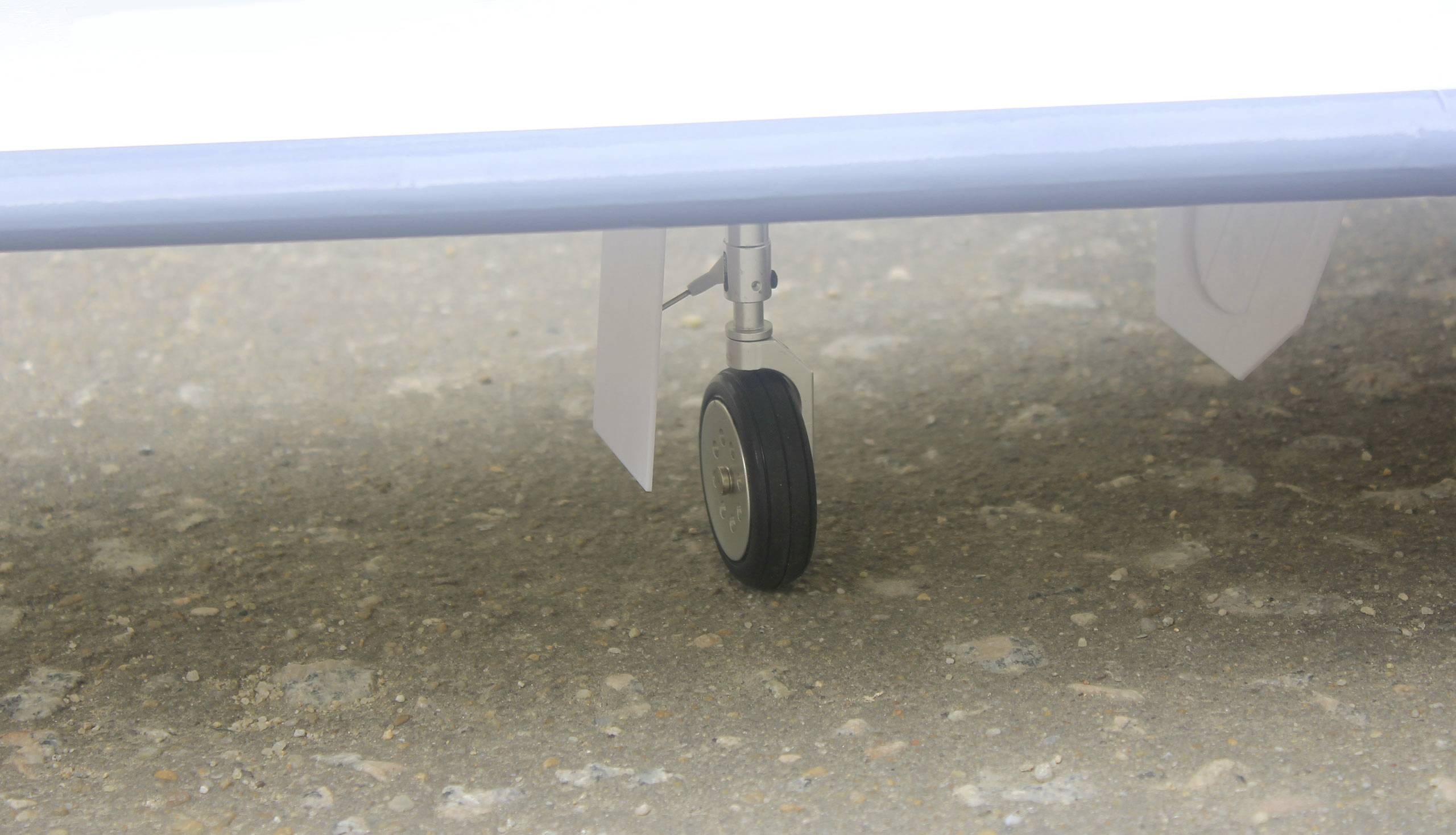 Kleines Rad eines Flugzeugfahrwerks, das den Boden berührt.
