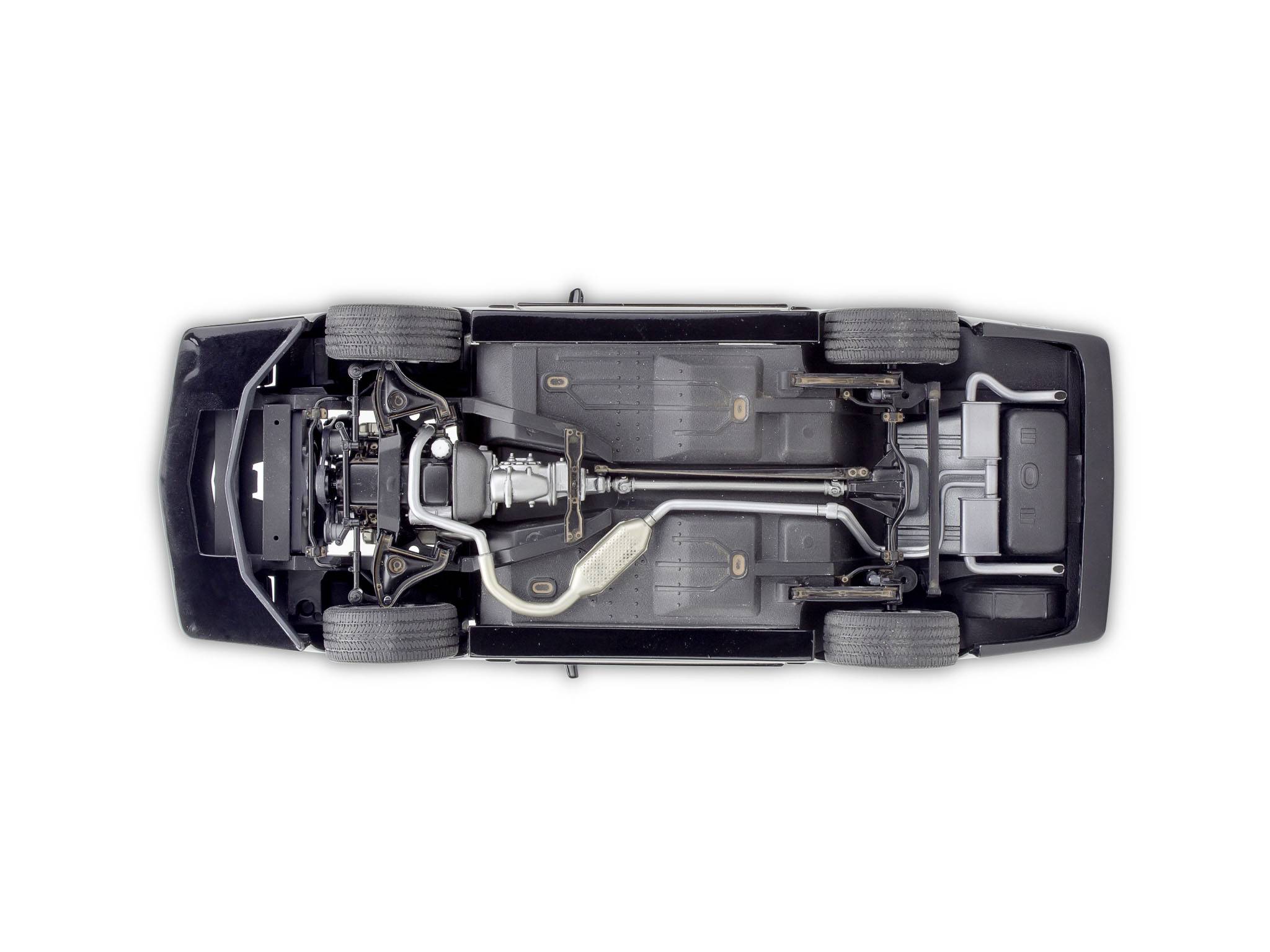 'Unterseite eines Autos, gezeigt mit Fahrgestell, Rädern, Auspuffanlage und Komponenten sichtbar.'